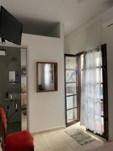a living room with a mirror on the wall at Chalé Rochat Maresias in Maresias