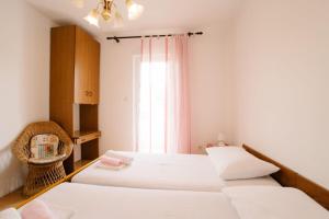 een slaapkamer met twee bedden en een raam bij Apartments Petri in Tisno