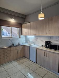 a kitchen with wooden cabinets and a white appliance at FlyHome Apartments near the Airport in Spáta