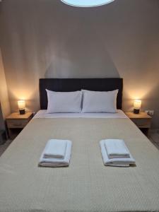 a bedroom with a large bed with two towels on it at FlyHome Apartments near the Airport in Spáta