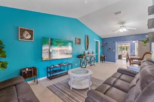 un soggiorno con divano e parete blu di Home with pool and canal access to ocean a Port Charlotte