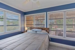 una camera da letto con pareti blu e finestre con un letto di Home with pool and canal access to ocean a Port Charlotte Altre 37 foto
