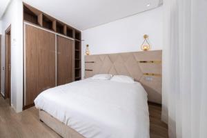 a bedroom with a large white bed with a wooden headboard at Luxury Duplex 3 Suites -Front Pool-Direct Pool Access in Marrakesh