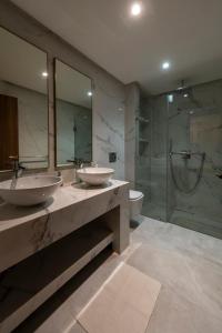 a bathroom with two sinks and a shower at Luxury Duplex 3 Suites -Front Pool-Direct Pool Access in Marrakesh