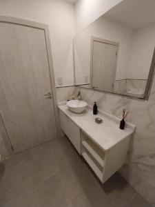 a white bathroom with a sink and a mirror at Prado del Lago in Villa Rumipal +4 photos