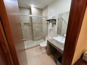 a bathroom with a shower and a toilet and a sink at Hotel Ave Inn Mazatlán in Mazatlán