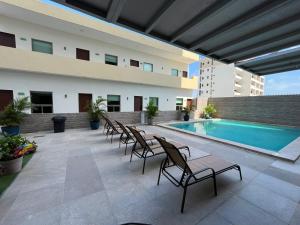 a patio with chairs and a pool in a building at Hotel Ave Inn Mazatlán in Mazatlán +34 photos