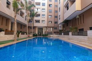 an empty swimming pool in front of a building at Luxury Duplex 3 Suites -Front Pool-Direct Pool Access in Marrakesh +11 photos