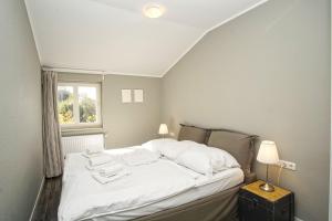 ein Schlafzimmer mit einem weißen Bett mit einem Fenster in der Unterkunft gratis Nutzung vom AHOI Erlebnisbad und Sauna in Sellin - Kurhaus Nordstrand FeWo 44 in Göhren