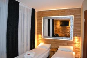 a bedroom with two beds and a mirror on the wall at VILLA VIP POKOJE pracownicze in Gniezno