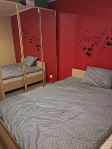 a bedroom with a bed and a red wall at VILLA VIP POKOJE pracownicze in Gniezno