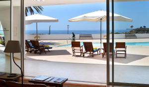 a view of a pool with chairs and umbrellas at Casa Três Palmeiras in Portimão +21 photos