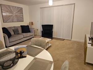 a living room with a couch and a table at The Joyland House in Romsey