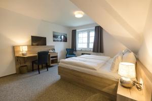 a bedroom with a bed and a desk with a computer at Cuxlandhotel Studio 124 in Dorum Neufeld