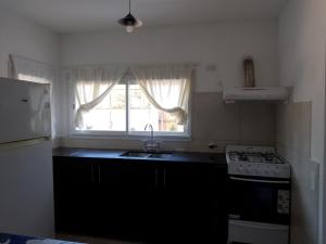a kitchen with a sink and a stove and a window at Casa Praga in Ostende