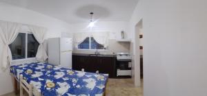 a small kitchen with a table and a refrigerator at Casa Praga in Ostende