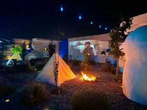 a person is standing next to a tent and a fire at Hacienda con Albercas Climatizadas in San Miguel de Allende