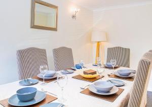 a table with chairs and plates and glasses on it at Central 2 Bed House w/ Garden and Free Parking! in Cheltenham