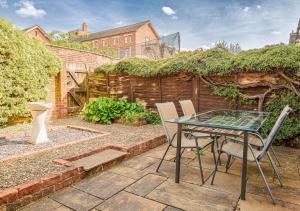 a patio with a glass table and two chairs at Central 2 Bed House w/ Garden and Free Parking! in Cheltenham