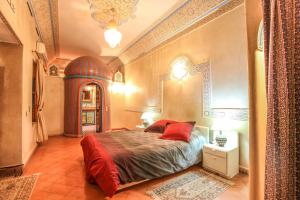 a bedroom with a bed with red pillows on it at Riad Puchka in Marrakech