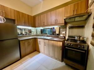a kitchen with wooden cabinets and a stove top oven at Mirea Residences Pasig- Two Bedroom Condo Unit with Balcony 70sqm in Manila