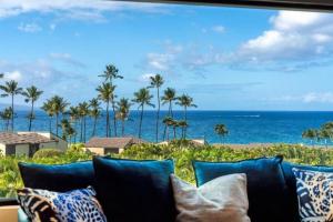 a couch with a view of the ocean and palm trees at WAILEA ELUA, #0802 condo in Wailea