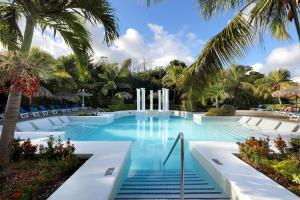 a swimming pool with palm trees and blue water at Grand Palladium Jamaica Resort & Spa All Inclusive in Lucea