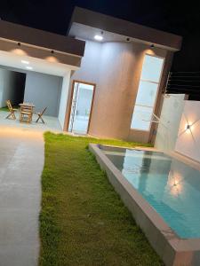 a house with a swimming pool in the middle of it at Bela casa jacumã in Conde