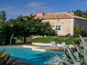 a house with a swimming pool and two white chairs at Gites de Saint Maurin in Monjoi