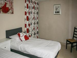 a small bedroom with a bed and a chair at Gite La Sempesserre in Monjoi +7 photos