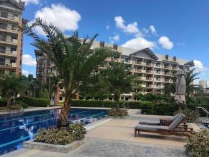 a resort with a palm tree and a swimming pool at Mirea Residences Pasig- Two Bedroom Condo Unit with Balcony 70sqm in Manila