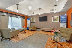 a waiting room with couches and a flat screen tv at Best Western Magnolia Inn and Suites in Ladson