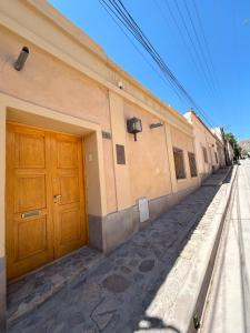 a building with wooden doors on the side of a street at La Elegida in Tilcara +23 photos