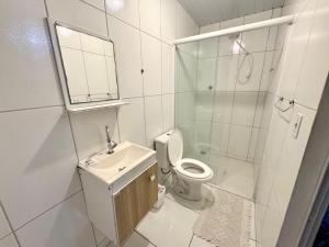 a bathroom with a toilet and a sink and a shower at Pousada da Cia in Blumenau