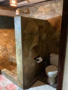 ein Badezimmer mit Toilette und Steinwand in der Unterkunft 1 bedroom apartment 150m from the Bay of San Juan in San Juan del Sur + 9 Fotos