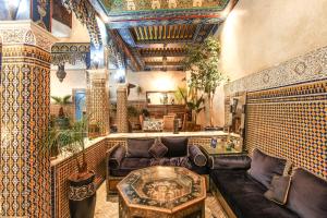 a living room filled with furniture and a large window at Riad Puchka in Marrakesh