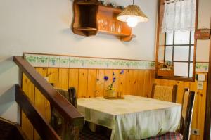 a dining room table with a vase of flowers on it at Chalés Recanto da Fonte Monte Verde - MG in Monte Verde