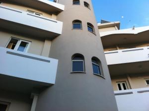 a tall building with windows on the side of it at Fantasia Hotel Apartments in Kos