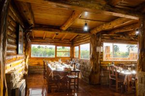 a restaurant with tables and chairs in a room with wooden walls at Hostería La Portada in Trevelín