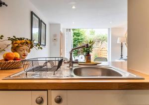 a kitchen sink with a bowl of fruit on the counter at Poppy Cottage - Cosy 2 Bedroom, Perfect for Family! in Shottery +72 photos