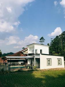 a white house with a fence in front of it at Princess Villa in Pasirjambu