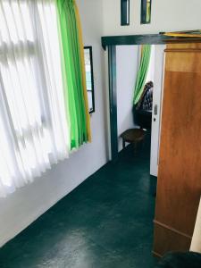 a living room with a green floor and curtains at Princess Villa in Pasirjambu