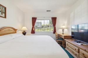 a bedroom with a large bed and a flat screen tv at Grand Wood Suites - 1st Floor Front Side Suite 104 in Nashville