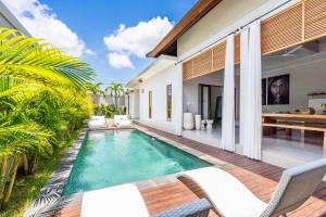 a swimming pool in the backyard of a villa at Villa Gaia Canggu in Canggu +24 photos