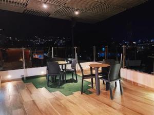 a room with tables and chairs and a view of a city at Hotel Terraza in Cali