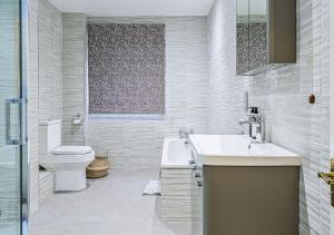 a white bathroom with a sink and a toilet at Charming 3BD Cotswolds Family Retreat in Bourton on the Water +52 photos