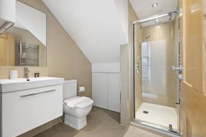 a bathroom with a toilet and a sink and a shower at Stylish 1-Bed Flat in Prime Kensington Location in London