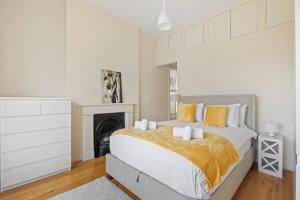 a white bedroom with a bed and a fireplace at Stylish 1-Bed Flat in Prime Kensington Location in London