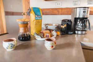 a counter with three cups of coffee on a counter top at Fairplay Coyote Cabin in Fairplay