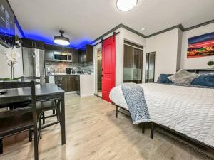 a bedroom with a bed and a desk and a kitchen at Modern condo near Fremont Street in Las Vegas